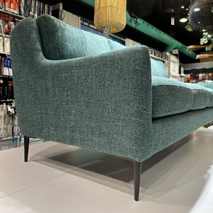 side view of custom green tweed sofa with black metal legs