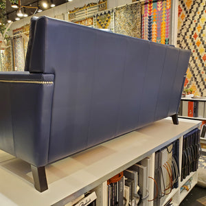 back view of custom sofa done in blue genuine leather with pewter nail heads on the inside and outside arms