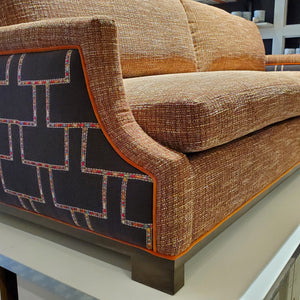 custom sofa in stain-resistant nubbly textured fabric, contrast embroidered fabric on the arms and orange velvet piping