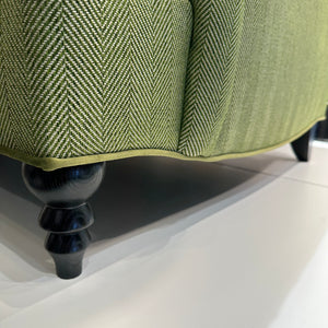 wood legs on green upholstered sofa