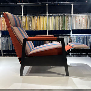 Side view of the Cambridge recliner in striped wool with corduroy piping in burnt orange, in reclined position.