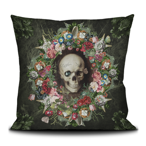 Decorative velvet throw pillow with skull and flowers.