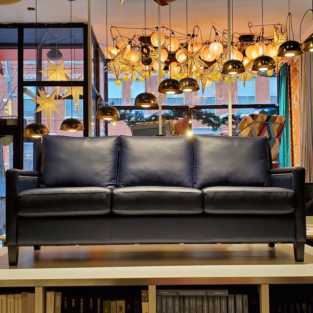 custom sofa done in blue genuine leather with pewter nail heads on the inside and outside arms