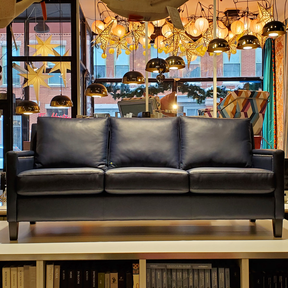 custom sofa done in blue genuine leather with pewter nail heads on the inside and outside arms