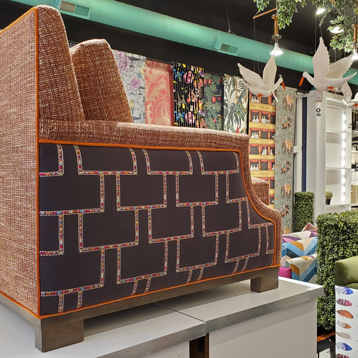 custom sofa in stain-resistant nubbly textured fabric, contrast embroidered fabric on the arms and orange velvet piping