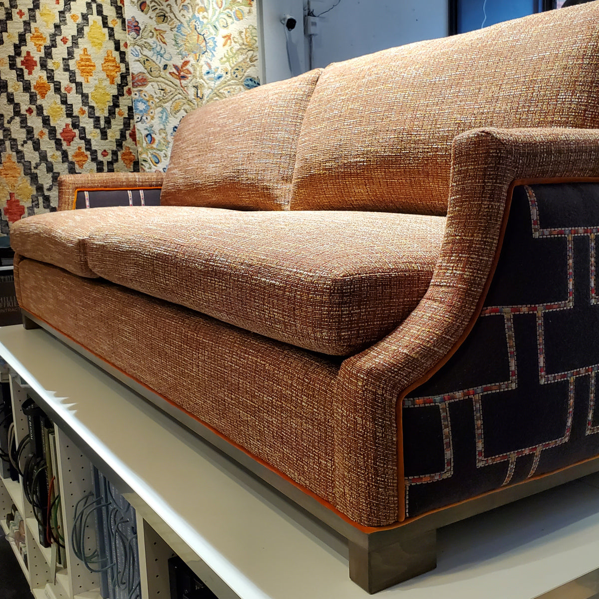 custom sofa in stain-resistant nubbly textured fabric, contrast embroidered fabric on the arms and orange velvet piping